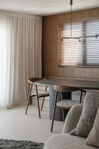 Interieur kustappartement met houtfineer panelen en grijze Socrete gietvloer