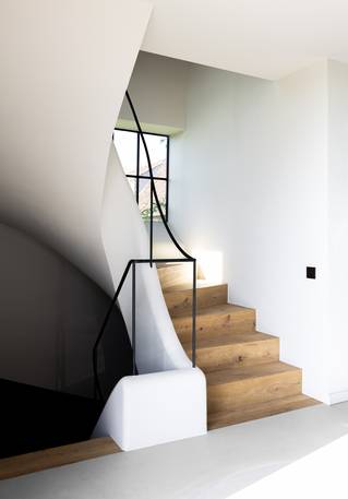 grijze Socrete gietvloer in rustieke gang met houten trappen