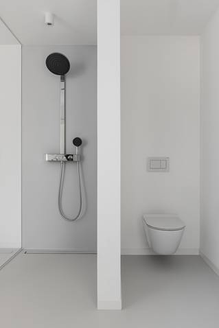 grijze Mellow PU gietvloer in badkamer met douche en toilet