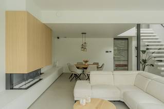 Woonkamer met haardmeubel en grijze Socrete gietvloer