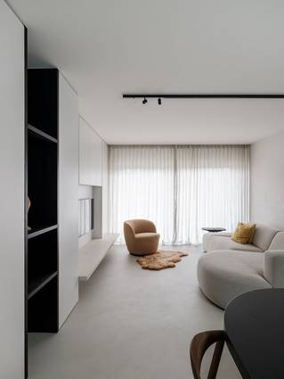 Woonkamer met grijze Socrete gietvloer in kustappartement