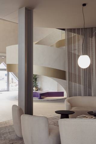 Zithoek met wenteltrap en grijze Socrete gietvloer in Picobello showroom