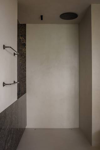 Minimalistische douche met grijze Socrete gietvloer en wanden