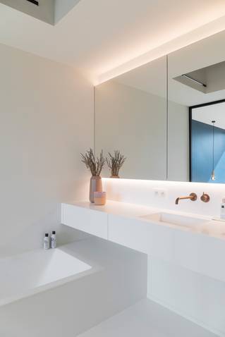 witte badkamer met bad en wastafel