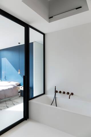 wit bad met uitzicht op slaapkamer