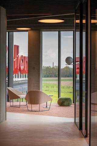 hal met zithoek op tapijt en socrete gietvloer