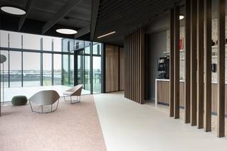 hal onderverdeeld in socrete gietvloer en tapijt