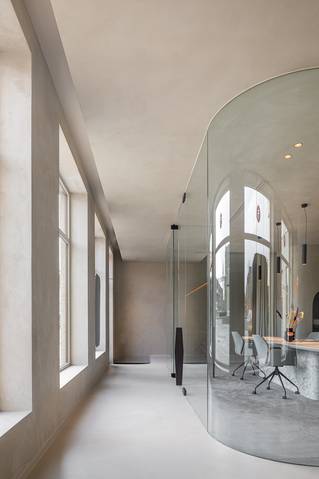 kantooromgeving met glazen werkkubus en Socrete vloer