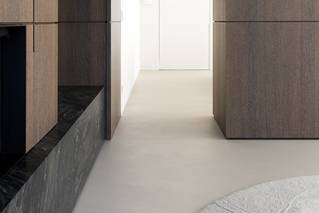 Socrete gietvloer in moderne woonkamer met houten meubilair