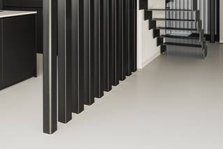 lichte Mellow PU gietvloer in zwarte keuken met metalen trap