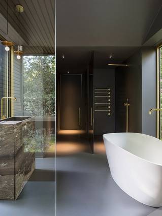 Zwarte badkamer met Mellow gietvloer en vrijstaand bad