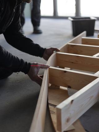 Schrijnwerker die houten maatwerk plaatst
