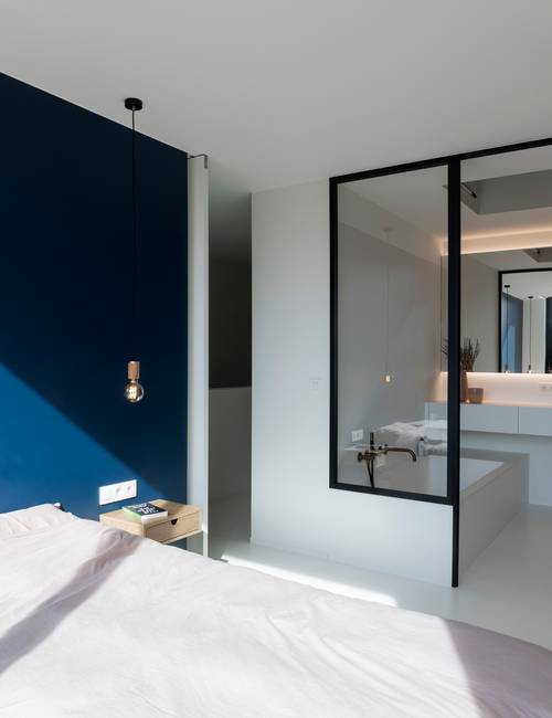 chambre à coucher avec mur en verre sur la salle de bain