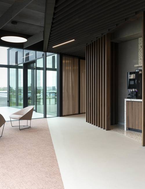 hal onderverdeeld in socrete gietvloer en tapijt