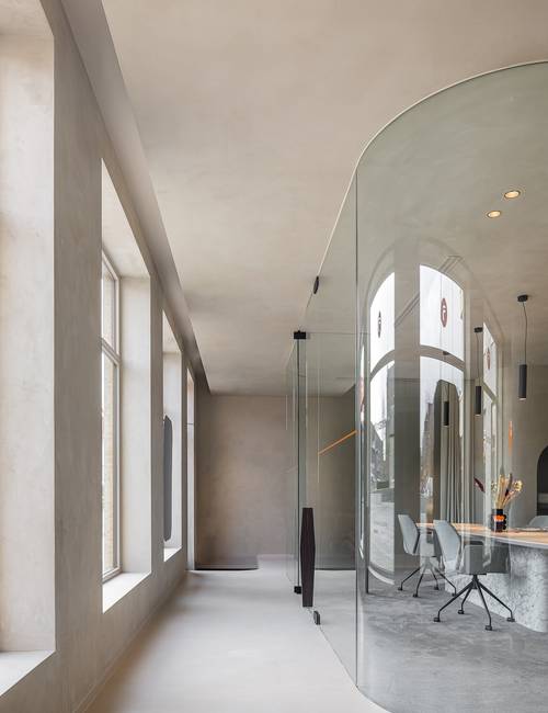 kantooromgeving met glazen werkkubus en Socrete vloer